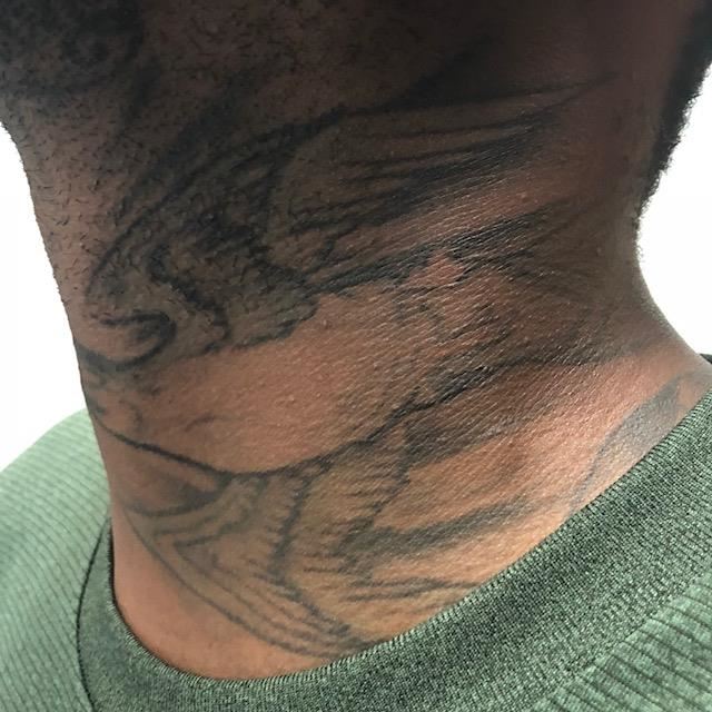 dark skinned neck with large bird tattoo